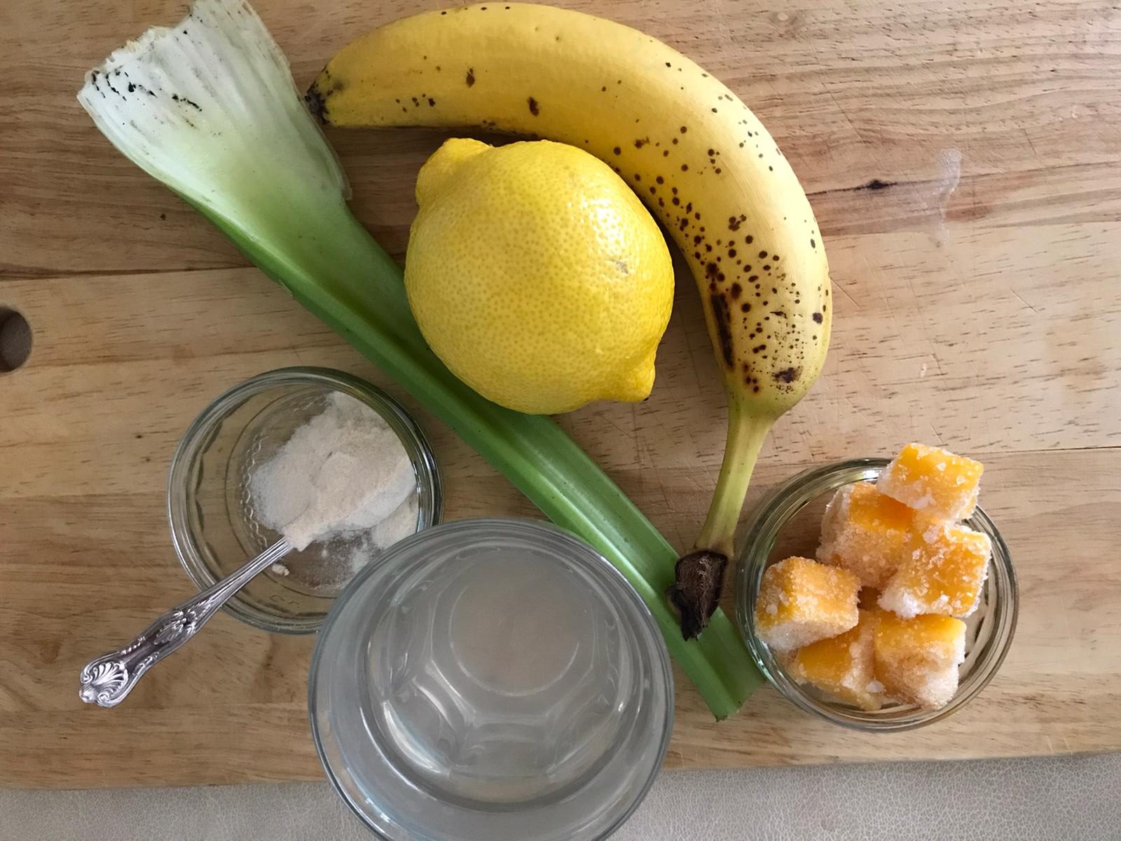 Frozen mango banana celeri and lemon smoothie ingredients.